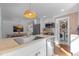 This bright kitchen features a sink, stainless steel appliances, white cabinets, and an adjacent laundry room at 116 W Front St, Oxford, NC 27565