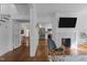 Inviting living room with hardwood floors, white walls, a fireplace, a large TV and an open floor plan at 116 W Front St, Oxford, NC 27565