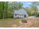 A charming backyard with a stone fire pit, surrounded by mature trees and green grass at 120 Kerigon Ln, Youngsville, NC 27596