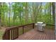 A backyard deck features a stainless steel grill, overlooking the mature trees at 120 Kerigon Ln, Youngsville, NC 27596