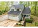 Elevated view of a two-story home with a two-car garage and covered front porch with chairs at 120 Kerigon Ln, Youngsville, NC 27596
