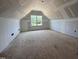 Unfinished attic space with a dormer window, offering potential for extra living area or storage at 125 Tee Dr, Selma, NC 27576