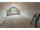 Unfinished bonus room with sloped ceilings and natural light at 125 Tee Dr, Selma, NC 27576