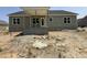 View of the rear exterior with covered porch on a one story home with horizontal siding and a dark shingled roof at 125 Tee Dr, Selma, NC 27576