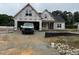 New construction home showing the front exterior with an attached garage in a partially developed lot at 125 Tee Dr, Selma, NC 27576