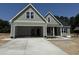 Two-story home featuring a two-car garage, shake siding and craftsman-style architectural details at 125 Tee Dr, Selma, NC 27576