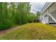 Expansive backyard with a gentle slope, mature trees, and access to natural surroundings at 12833 Edsel Dr, Raleigh, NC 27613