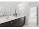 Bathroom with a dark vanity with double sinks and a large mirror at 12833 Edsel Dr, Raleigh, NC 27613