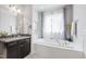 Elegant bathroom with a soaking tub, vanity, and decorative window at 12833 Edsel Dr, Raleigh, NC 27613