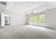 Bright bedroom with tray ceiling, light fixture, and a large window at 12833 Edsel Dr, Raleigh, NC 27613