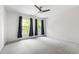 Cozy bedroom with ceiling fan, neutral carpet, bright walls, and large windows at 12833 Edsel Dr, Raleigh, NC 27613