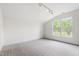 Bright bedroom with a large window, neutral carpet, and a walk-in closet at 12833 Edsel Dr, Raleigh, NC 27613