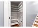 Walk-in closet with multiple shelves, rod, and storage space adjacent to the stairs at 12833 Edsel Dr, Raleigh, NC 27613