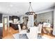 Open concept dining room with modern light fixture flows seamlessly into the kitchen and living spaces at 12833 Edsel Dr, Raleigh, NC 27613