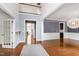 Bright foyer featuring hardwood floors, wainscoting, an open staircase, and views into other living spaces at 12833 Edsel Dr, Raleigh, NC 27613
