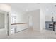 Bright hallway features neutral carpet, white walls, wooden railing and light fixtures at 12833 Edsel Dr, Raleigh, NC 27613