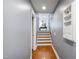 Hallway features gray walls, wood floors and staircase, and decorative wall storage at 12833 Edsel Dr, Raleigh, NC 27613