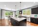 Well-lit kitchen featuring an island with cooktop and a view to dining area and outdoor patio at 12833 Edsel Dr, Raleigh, NC 27613