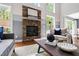 Inviting living room featuring a stone fireplace and large windows providing natural light at 12833 Edsel Dr, Raleigh, NC 27613
