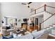 Open-concept living room with hardwood floors, staircase, and views into the kitchen and dining area at 12833 Edsel Dr, Raleigh, NC 27613
