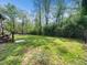 Large backyard surrounded by lush trees and vegetation and bordered with black metal fencing at 1301 Lynnwood Rd, Knightdale, NC 27545