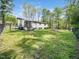 Spacious backyard with the house in the background and bordered with trees and greenery at 1301 Lynnwood Rd, Knightdale, NC 27545