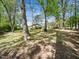 Backyard view of the house through the mature hardwoods at 1301 Lynnwood Rd, Knightdale, NC 27545