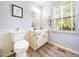 Bathroom features vanity, toilet, framed art, and a window that lets in natural light at 1301 Lynnwood Rd, Knightdale, NC 27545
