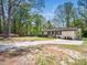 Spacious front yard with mature trees, a single-story home and a circular driveway at 1301 Lynnwood Rd, Knightdale, NC 27545