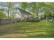 Spacious backyard with a green lawn, wooden fence, deck and mature trees, providing privacy at 13816 N Meadows Ct, Wake Forest, NC 27587