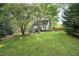 Expansive backyard with mature trees, a firepit, deck, and shed, perfect for outdoor entertaining at 13816 N Meadows Ct, Wake Forest, NC 27587
