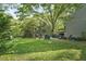 Lush backyard featuring mature trees, a deck, patio, and outdoor seating areas for relaxation at 13816 N Meadows Ct, Wake Forest, NC 27587