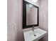 Powder room with pedestal sink, black framed mirror, and light pink walls at 1401 Freshwater Ct, Wake Forest, NC 27587
