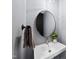 Modern powder room featuring a sleek pedestal sink, round mirror, and stylish fixtures at 1401 Freshwater Ct, Wake Forest, NC 27587