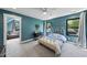 Cozy bedroom with blue walls featuring a white bed, plenty of light, and attached sitting area at 1401 Freshwater Ct, Wake Forest, NC 27587