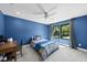 A blue bedroom features a gray carpet, desk, and two windows at 1401 Freshwater Ct, Wake Forest, NC 27587