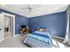 A blue bedroom features a gray carpet, desk, and doorway at 1401 Freshwater Ct, Wake Forest, NC 27587
