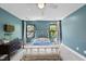 A cozy bedroom with two windows, gray carpet, and teal walls at 1401 Freshwater Ct, Wake Forest, NC 27587