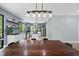 Open dining and kitchen area with modern lighting fixtures, stainless steel appliances, and large windows with a wooded view at 1401 Freshwater Ct, Wake Forest, NC 27587
