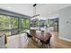 Spacious dining area with a large wooden table, modern lighting, and large windows offering scenic wooded views at 1401 Freshwater Ct, Wake Forest, NC 27587