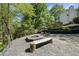 Backyard firepit with log bench seating, set in a gravel area with landscaped surroundings for outdoor enjoyment at 1401 Freshwater Ct, Wake Forest, NC 27587