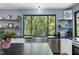 Modern kitchen featuring stainless steel appliances, black countertops, white cabinets, and a sink overlooking a wooded view at 1401 Freshwater Ct, Wake Forest, NC 27587