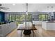 Open-concept living and dining area with scenic wooded views from large windows and hardwood flooring at 1401 Freshwater Ct, Wake Forest, NC 27587