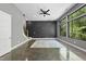 Bright living room with polished concrete floors, ceiling fan, and large windows overlooking a wooded area at 1401 Freshwater Ct, Wake Forest, NC 27587
