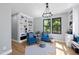 Bright living room featuring hardwood floors, custom built-ins, and large windows at 1401 Freshwater Ct, Wake Forest, NC 27587