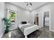Bedroom with queen bed, ceiling fan, large window, polished concrete floors, and closet with stackable washer/dryer at 1401 Freshwater Ct, Wake Forest, NC 27587