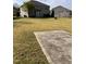 Large backyard featuring well-maintained lawn, mature trees, and a patio with outdoor seating at 141 Steel Hopper Way, Garner, NC 27529