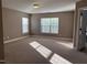 Spacious bedroom with neutral carpet, light-filled windows and adjoining doorway at 141 Steel Hopper Way, Garner, NC 27529