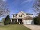 Charming two-story home featuring a stone facade, well-manicured lawn, and a welcoming entrance with a lovely front door wreath at 141 Steel Hopper Way, Garner, NC 27529