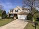 Charming two-story home featuring a manicured lawn, stone accents, a two-car garage, and a welcoming front porch at 141 Steel Hopper Way, Garner, NC 27529